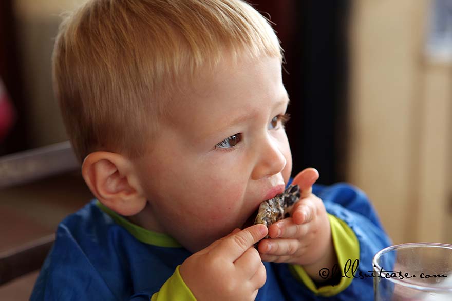Young child eating an oyster in Knysna, South Africa