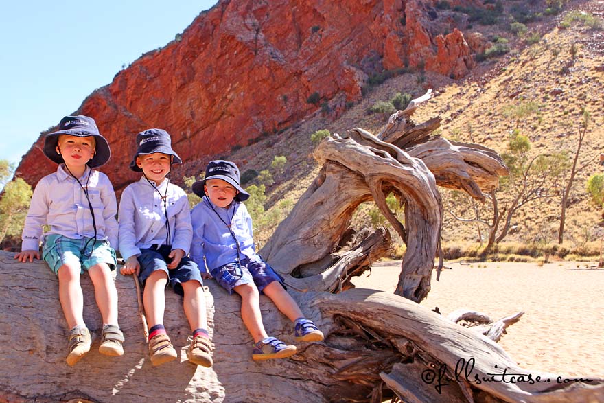 Three young boys tourists at Simpsons Gap in MacDonnell ranges Australia