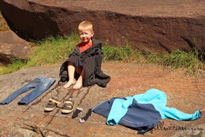young child traveling in Australia gets wet in natural pools