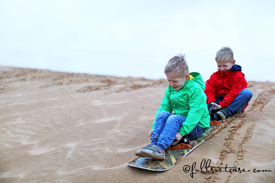 Dubai family activities - kids sand boarding in the desert