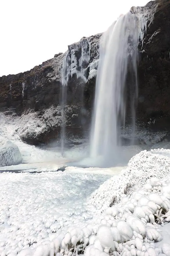 Partially frozen Seljalandsfoss waterfall in Iceland in winter