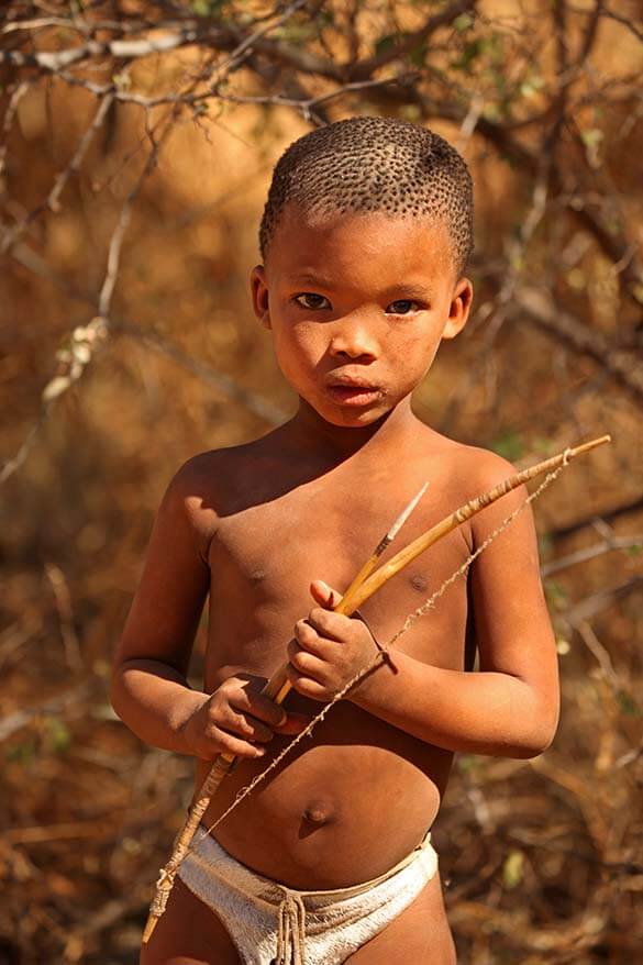Young bushmen boy from the San tribe in Namibia learning how to hunt