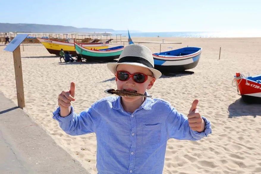 Boy eating dry fish in Nazare Portugal