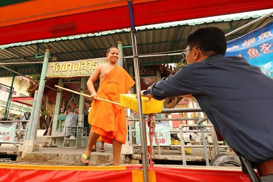 Buying bread for the fish from Buddhist monks at Wat Chinorot temple along Bangkok's canals