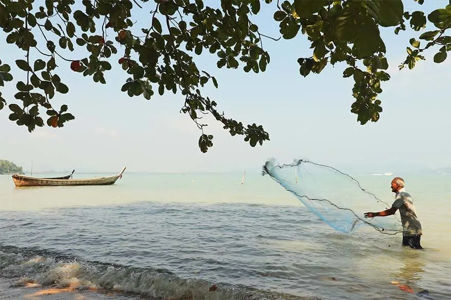 Local fisherman catching crab with a net in a village on Coconut Island near Phuket in Thailand