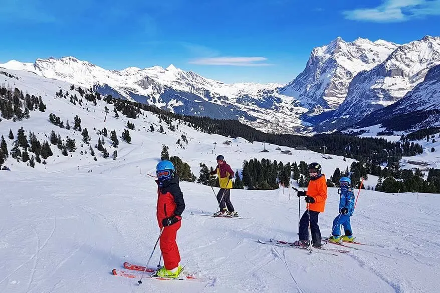 Family skiing with amazing views of Jungfrau Region ski area in winter - Switzerland
