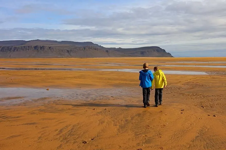 Kids walking on Raudisandur beach in Iceland