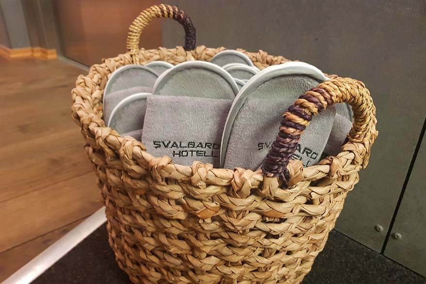 Korb mit Hausschuhen im Svalbard Hotel - es ist verboten, Ihre Outdoor–Schuhe an vielen Orten in Svalbard zu tragen's forbidden to wear your outdoor shoes inside many places in Svalbard