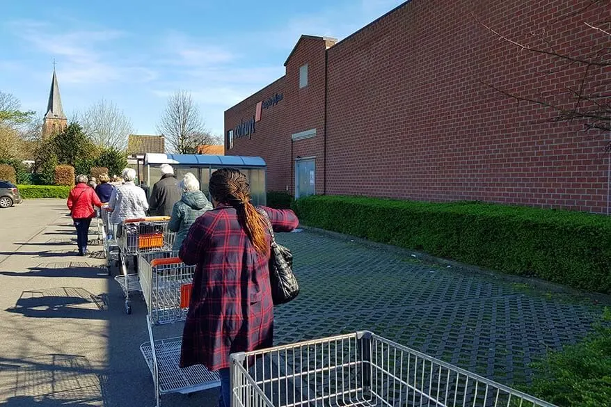 Row of people waiting to enter a supermarket - coronavirus in Belgium