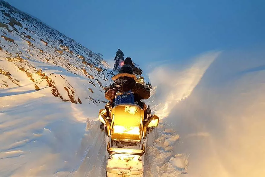 Snowmobiles driving through a canyon in Svalbard