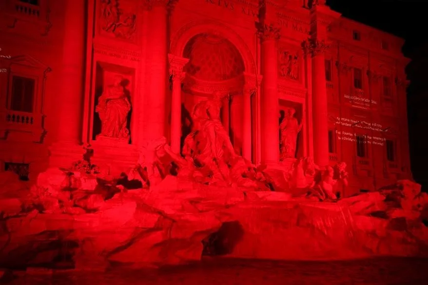 Trevi Fountain lit in red in the dark