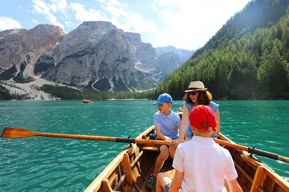 Family rowing a boat on Pragser Wildsee in the Dolomites Italy