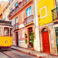 Yellow tram and colorful buildings in Lisbon Portugal