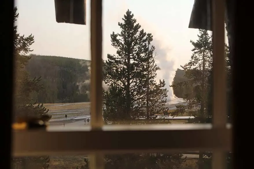 View on Old Faithful Geyser through a room window at the Old Faithful Inn hotel in Yellowstone National Park
