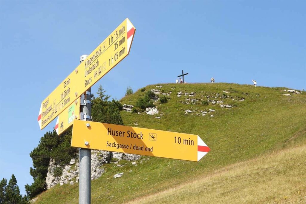 Huser Stock peak and hiking signs along the Stoos crest hike in Switzerland