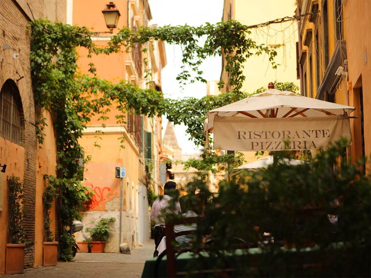Restaurant and colorful street in Trastevere neighborhood in Rome