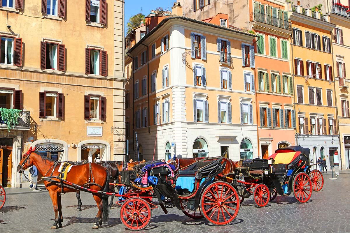 Colorful buildings and horse drawn carriage on Piazza di Spagna in Rome