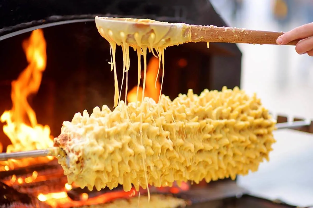 Sakotis ,sekacz, baumkuchen is traditional spit cake in lithuanian, polish,  german, belarusian cuisine made of butter, eggs, flour, sugar cooked on  rotating spit over open fire. Cup of tea. Horizontal by netatsi