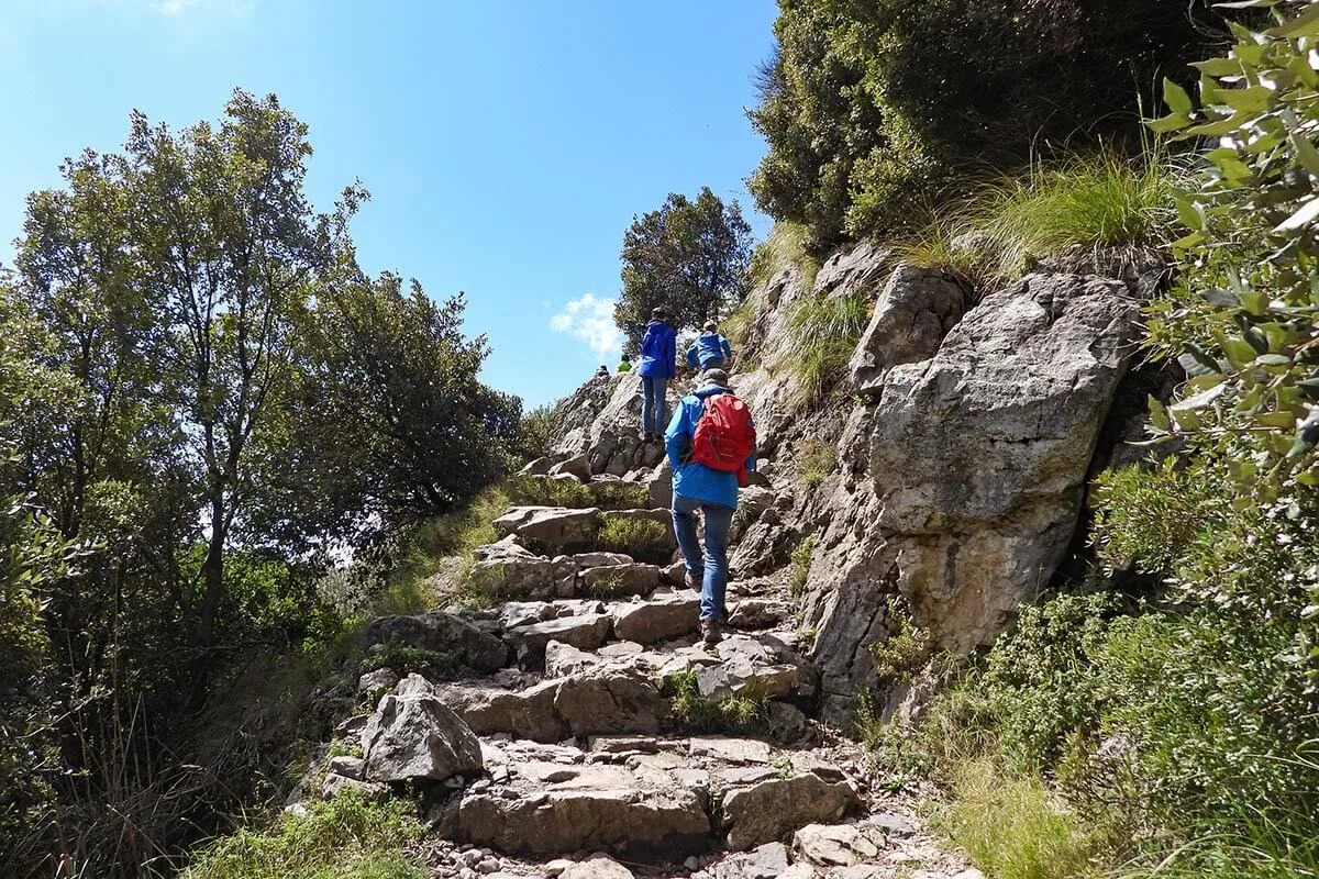 Climbing stone stairs on the Path of the Gods hiking trail in Italy