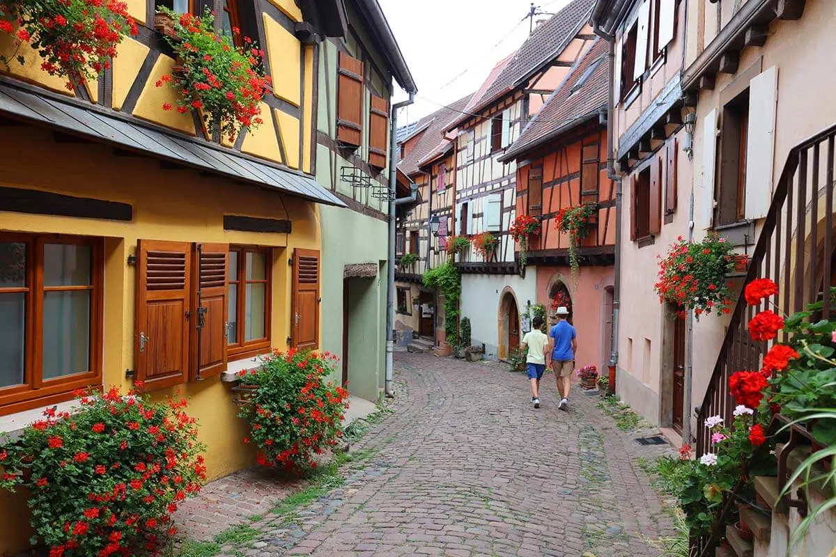 Walking on Rue du Rempart in Eguisheim town in Alsace, France