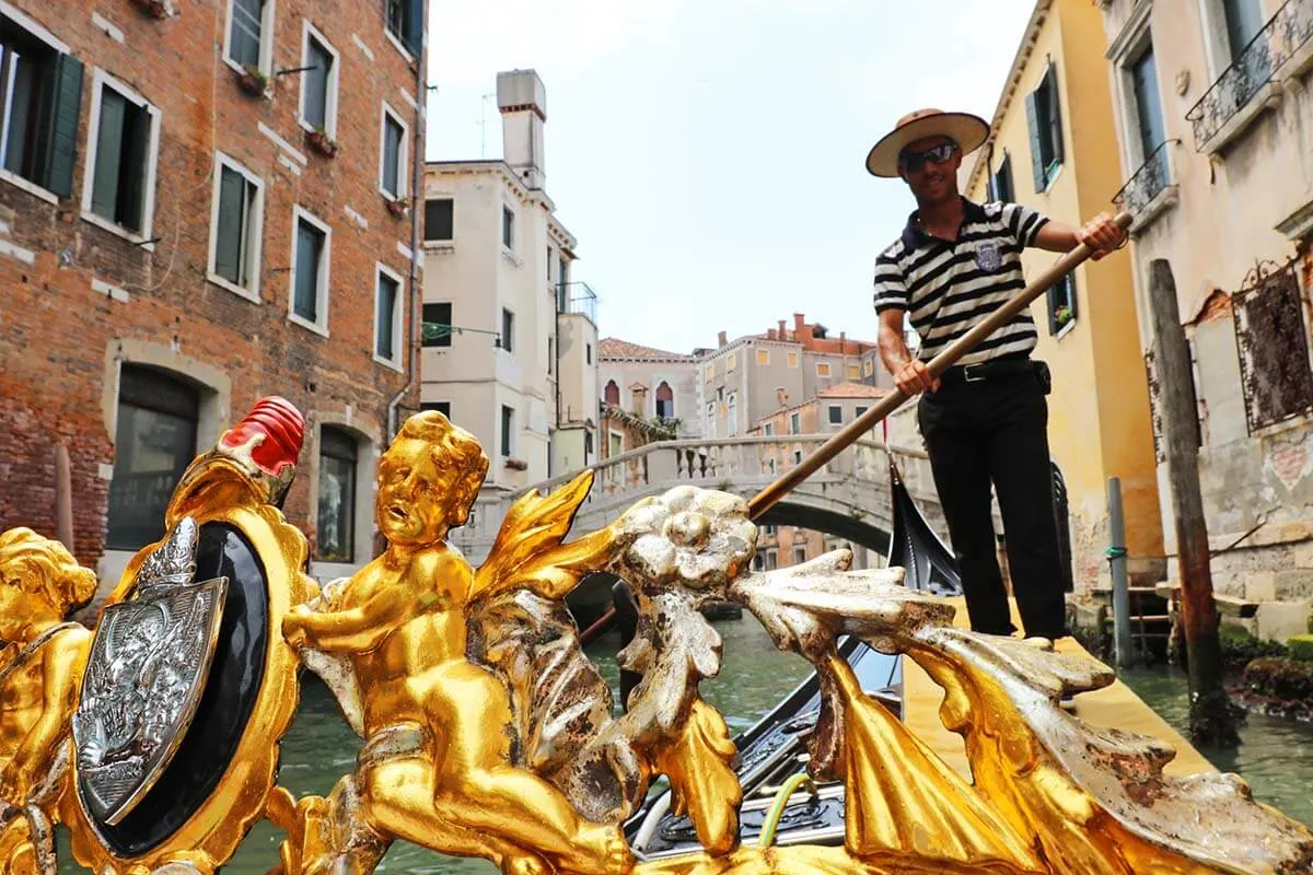 Gondolier steering a Venetian gondola in Venice