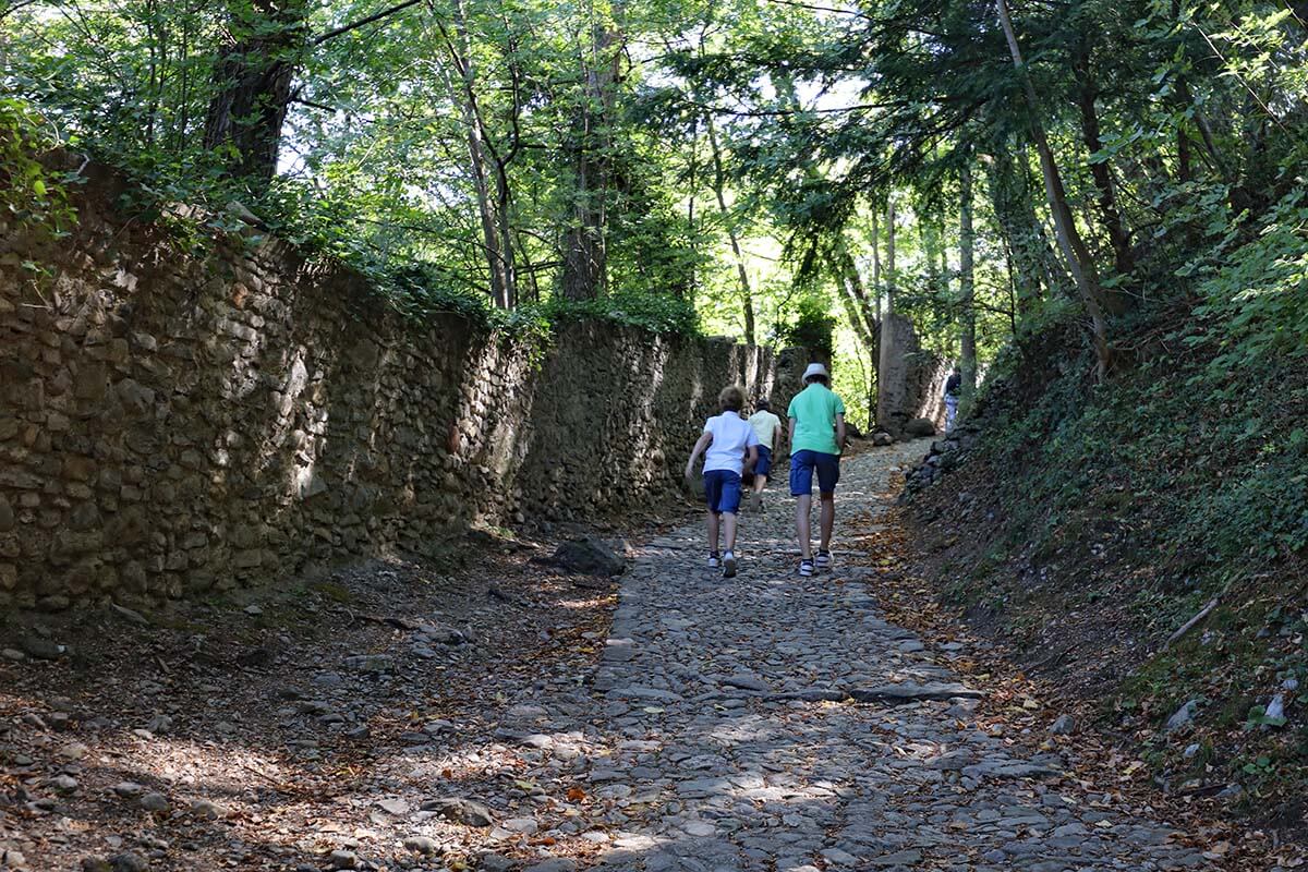 Kids walking on a cobbled path to Castello di Vezio in Varenna