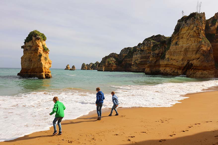 Portugal with kids - children playing on a beach in Algarve