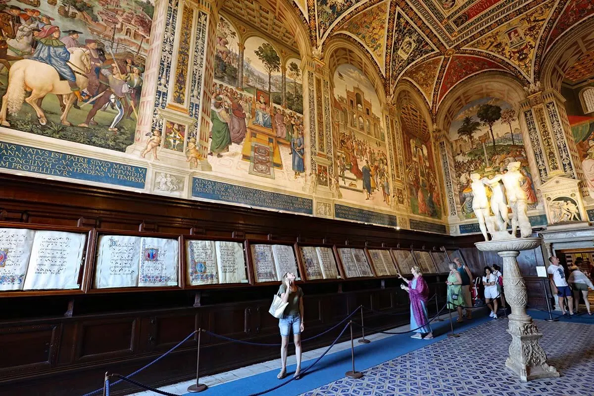 Visitors inside Piccolomini Library at Siena Cathedral in Italy