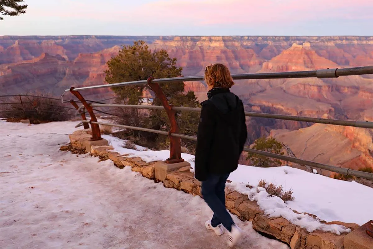 Child walking at an icy viewpoint of Grand Canyon South Rim in winter
