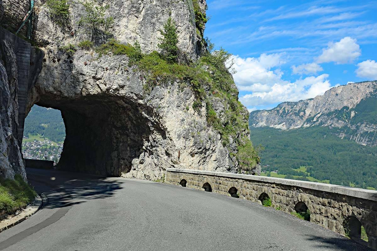 Driving in the Dolomites - mountain road with a narrow tunnel