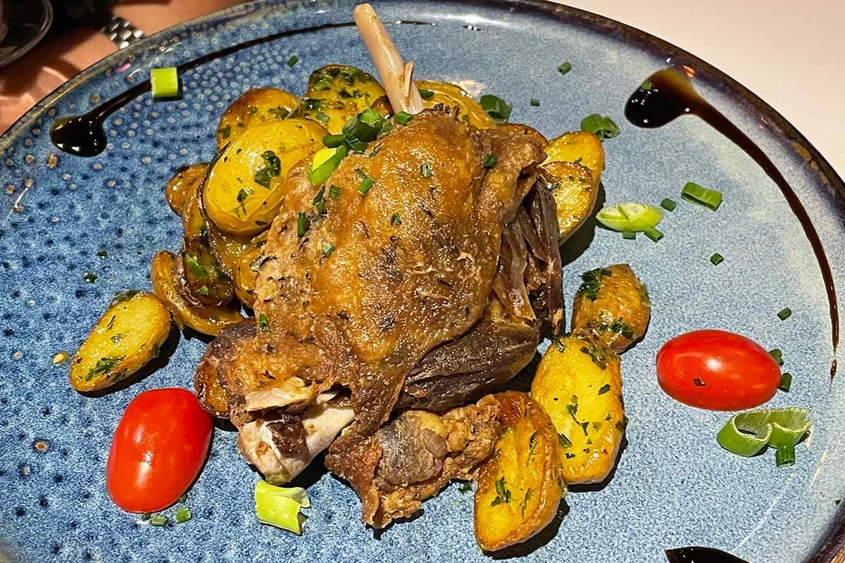 French foods - duck confit (confit de canard) served at a restaurant in Paris