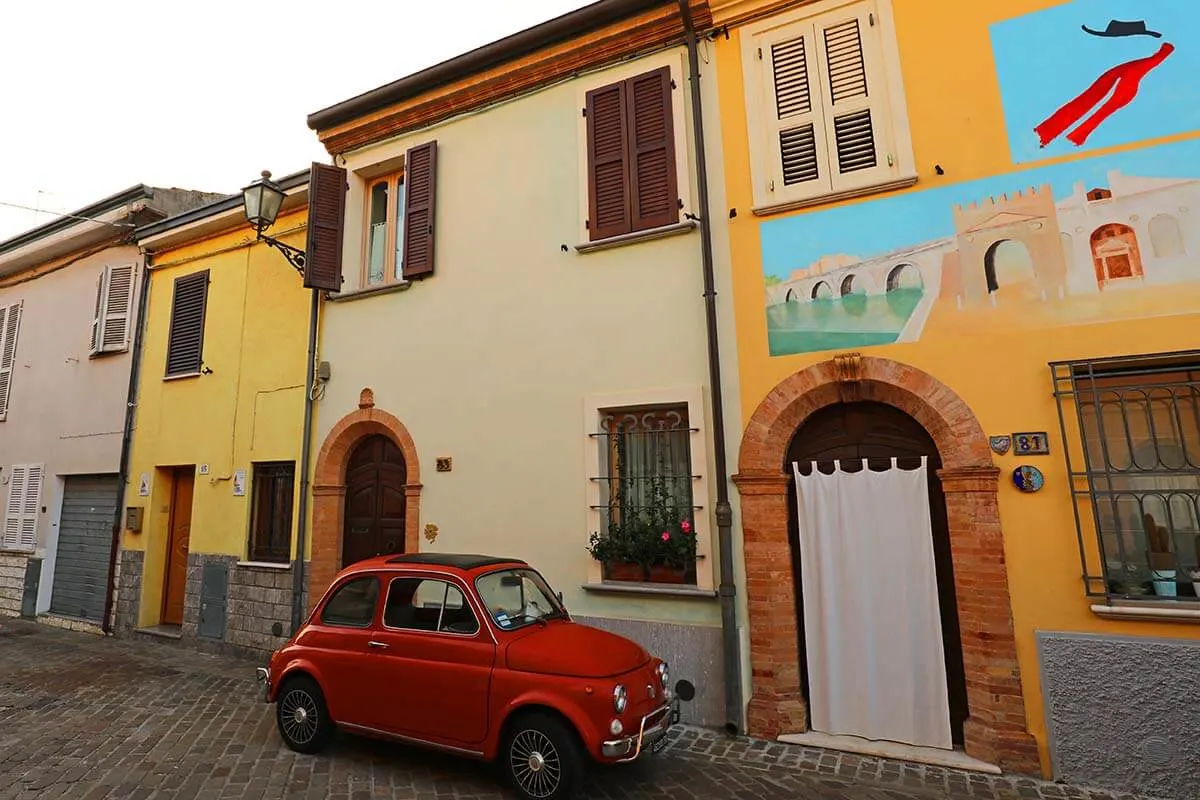Colorful street and a red car in Borgo San Giuliano fishermen's neighborhood in Rimini