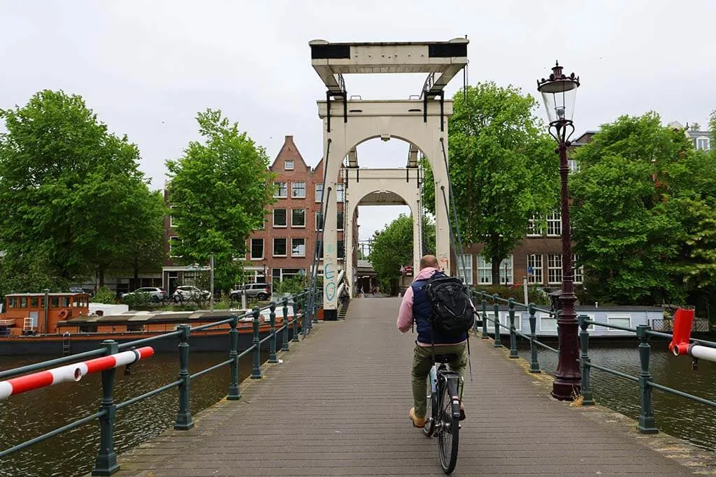 Amsterdam bike tour - biking over a traditional bridge in Westelijke Eilanden district in Amsterdam