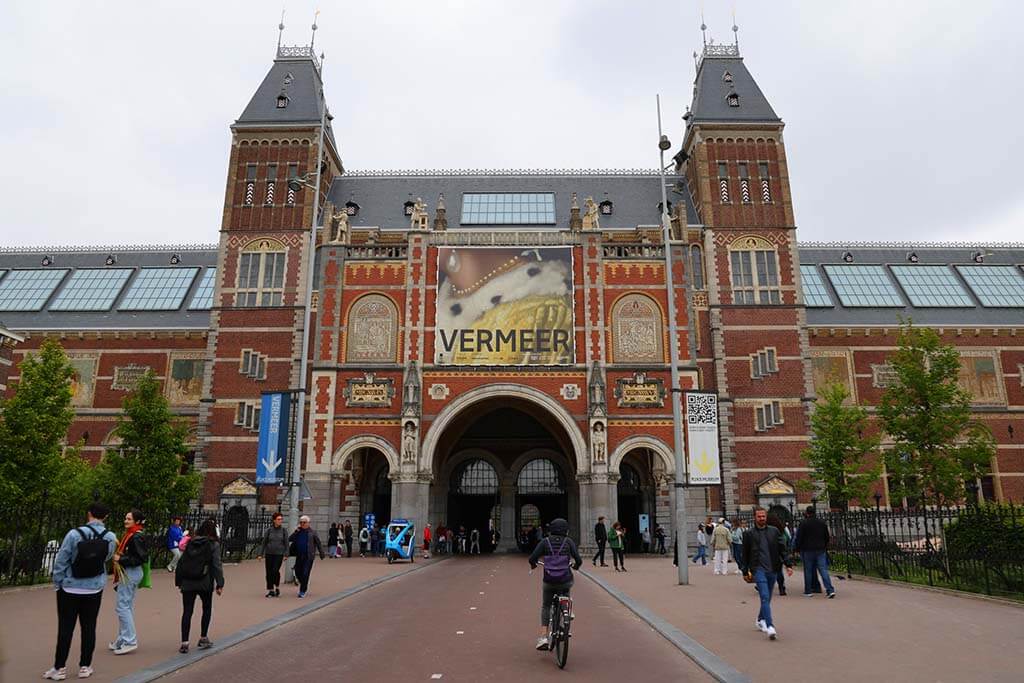 People in front of Rijksmuseum building on a grey cold day in Amsterdam in June