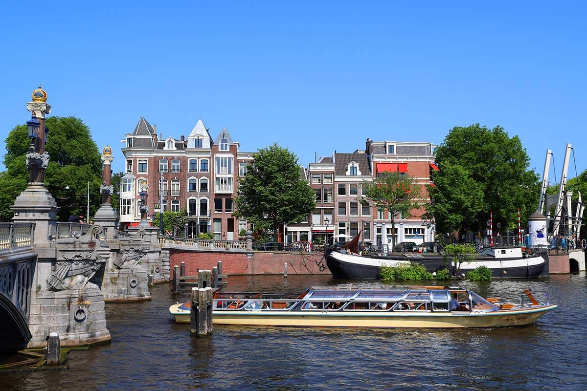 Sightseeing cruise on Amstel River at The Blue Bridge (Blauwbrug) in Amsterdam Holland