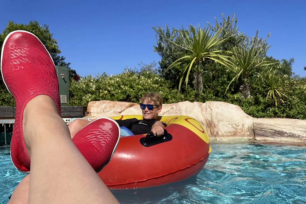 Feet with water shoes at Rio do Cocos lazy river water attraction at Zoomarine Algarve