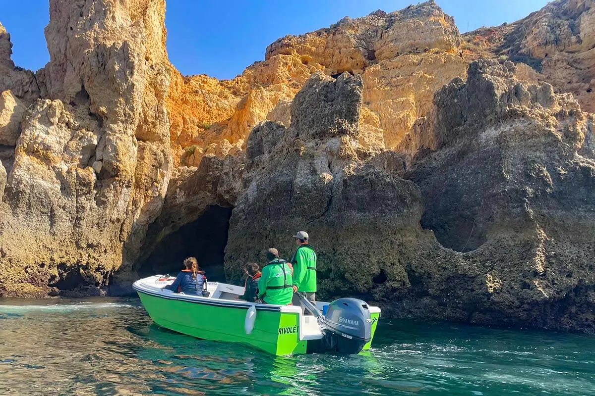 Small boat exploring sea grottos in Algarve Portugal