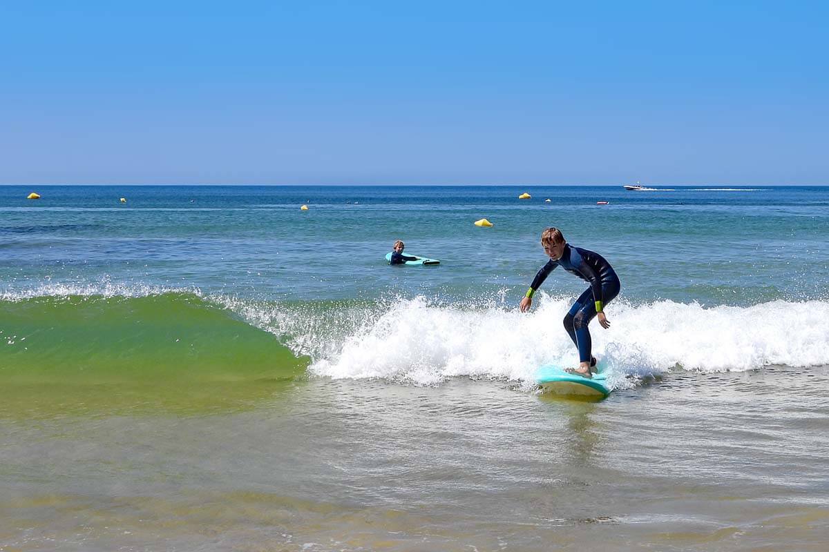 Kids surfing on Falesia Beach in Algarve