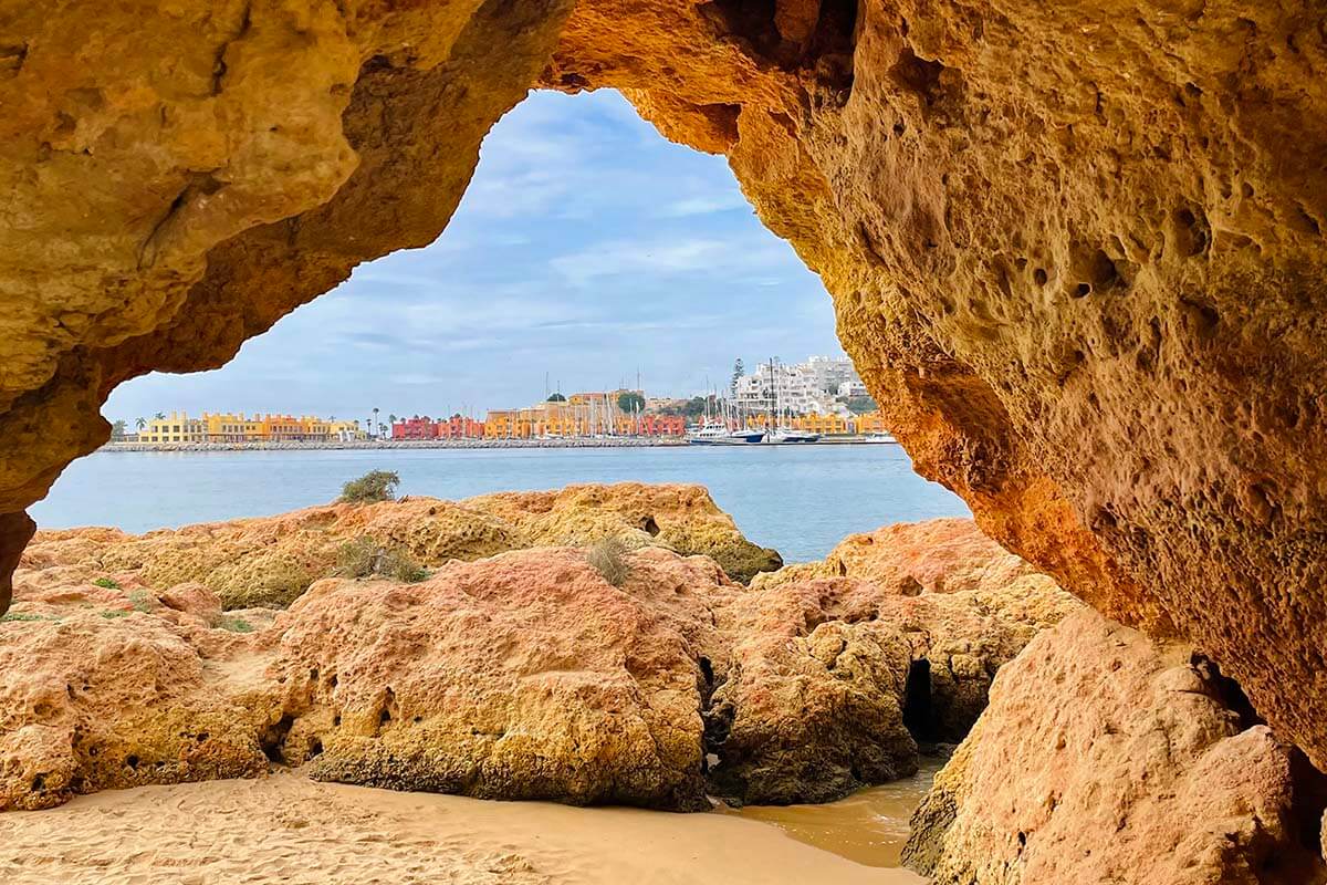 Natural Arch on Praia Grande in Ferragudo with the view of Portimao in the distance - Algarve road trip itinerary