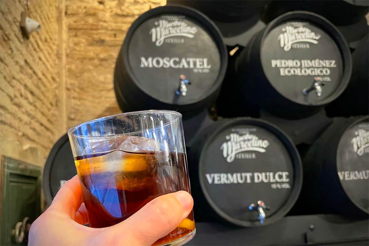 Vermouth wine glass and barrels at a traditional abacería in Seville Spain