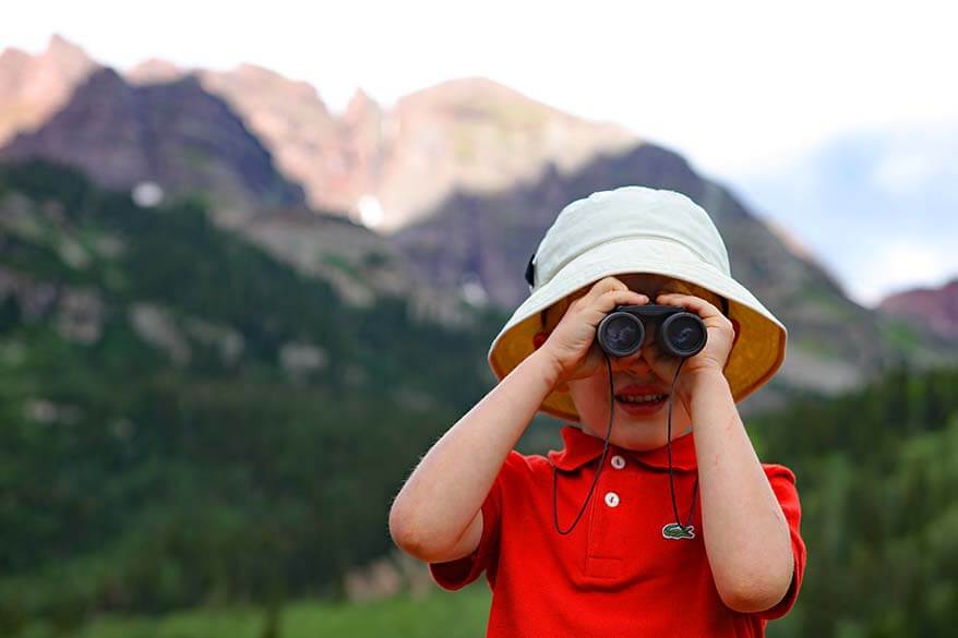 Child with binoculars in the mountains