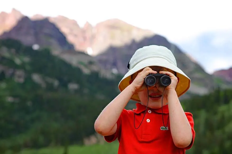 Child with binoculars in the mountains