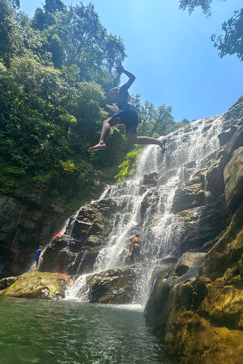 Kids jumping off the cliffs at Nauyaca Waterfalls in Costa Rica