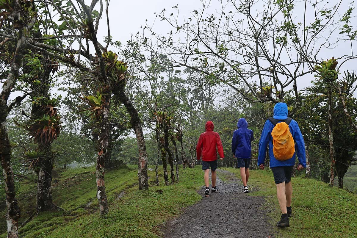 People wearing rain jackets hiking in tropical rain in Arenal Costa Rica