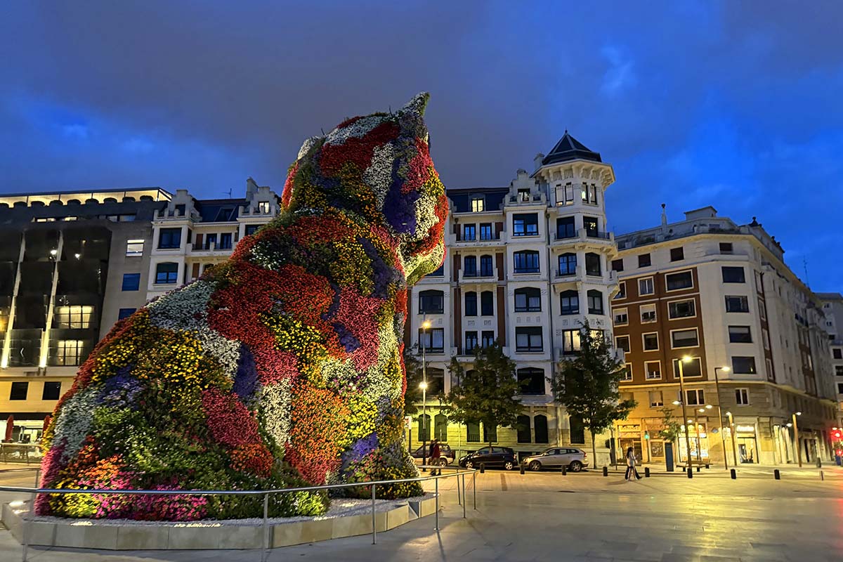 Puppy sculpture in Bilbao lit in the evening