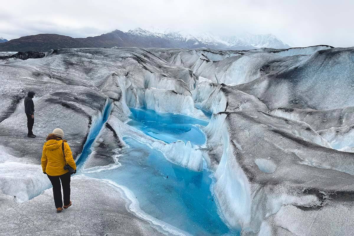 Walking between blue pools on the Knik Glacier in Alaska