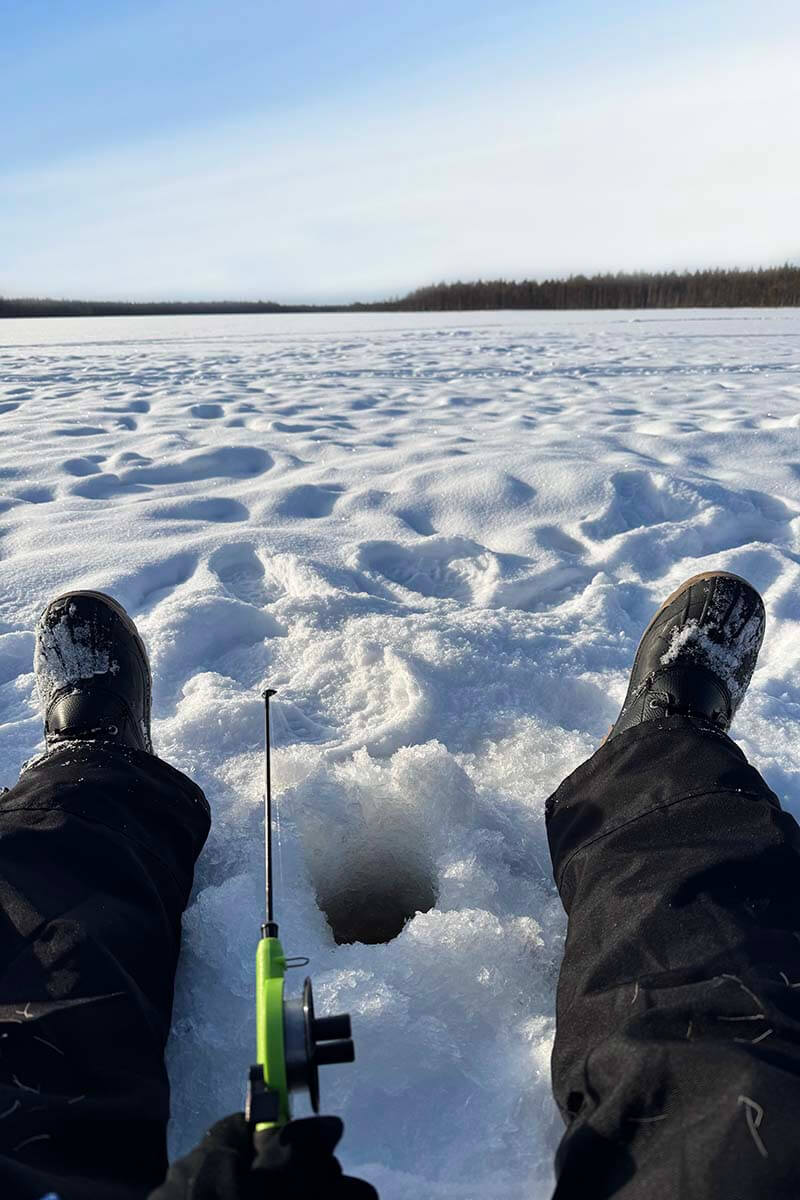 Ice fishing on a frozen lake - fun things to do in Rovaniemi Lapland