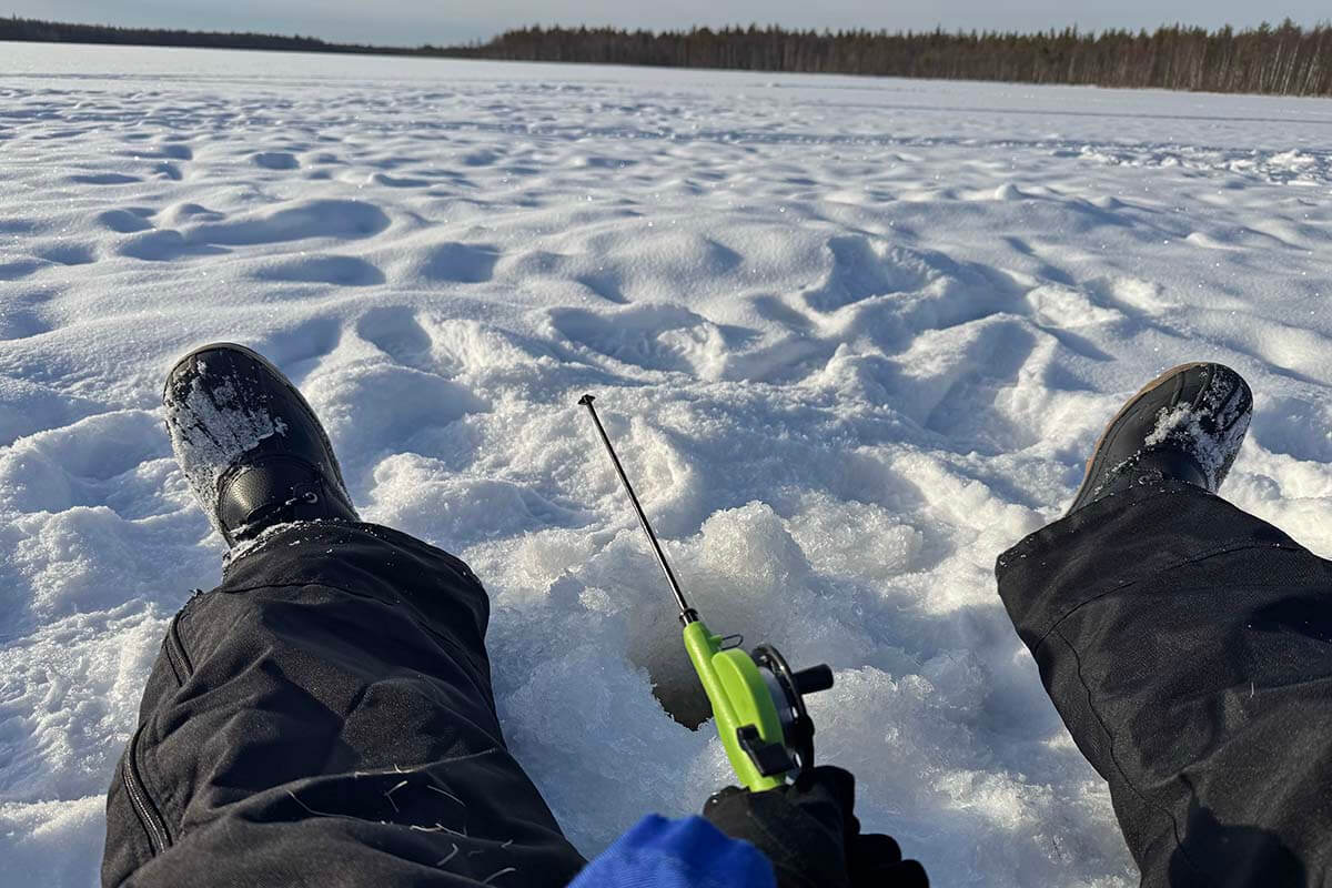 Ice fishing on a frozen lake in Rovaniemi in winter