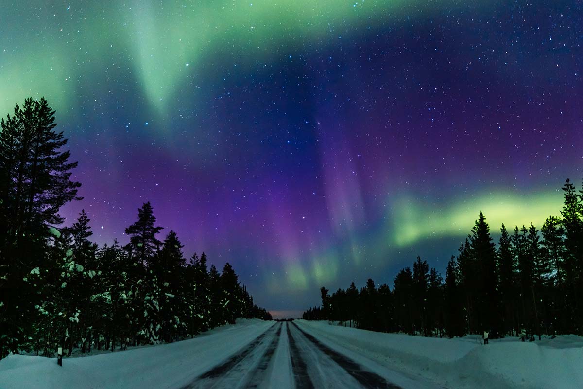 Northern Lights and an icy road in Lapland Finland