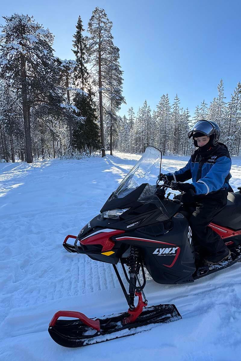 Snowmobiling in a snowy forest in Rovaniemi Lapland